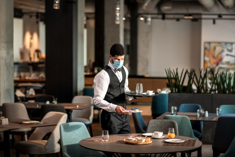 Pincér szolgál fel egy étteremben - További drágulás jön az éttermekben Magyarországon