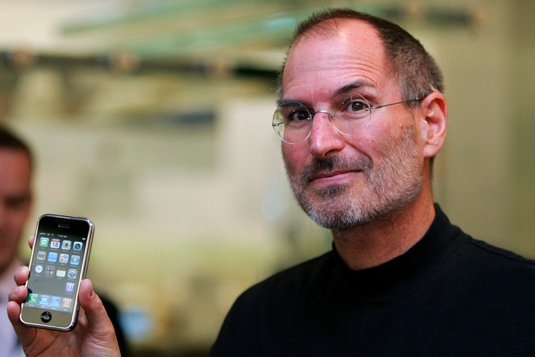 Steve Jobs 2007-ben kezében egy iPhone készülékkel Londonban - visszatér az Apple bohóchalas háttérképe