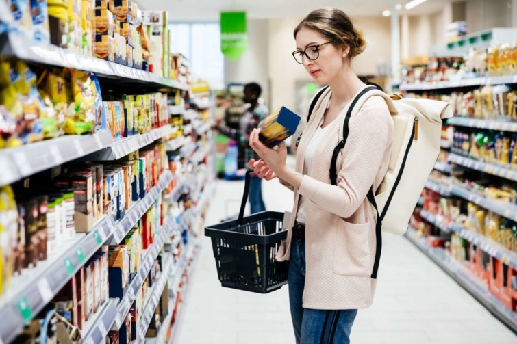 Fiatal nő nézi egy termék árát a boltban