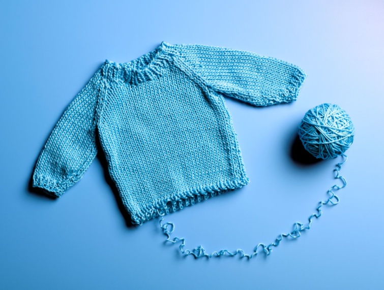 Gyapjúból készült kék pulóver, kék gyapjú gombolyaggal