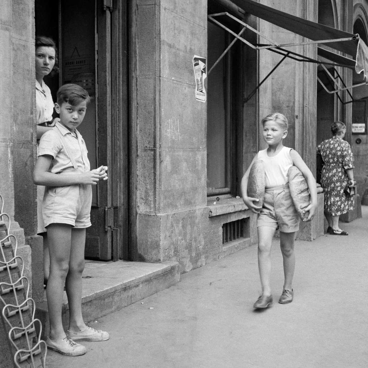 Kenyeret cipel egy nyári délután a József Attila utcában egy fiú, Budapesten