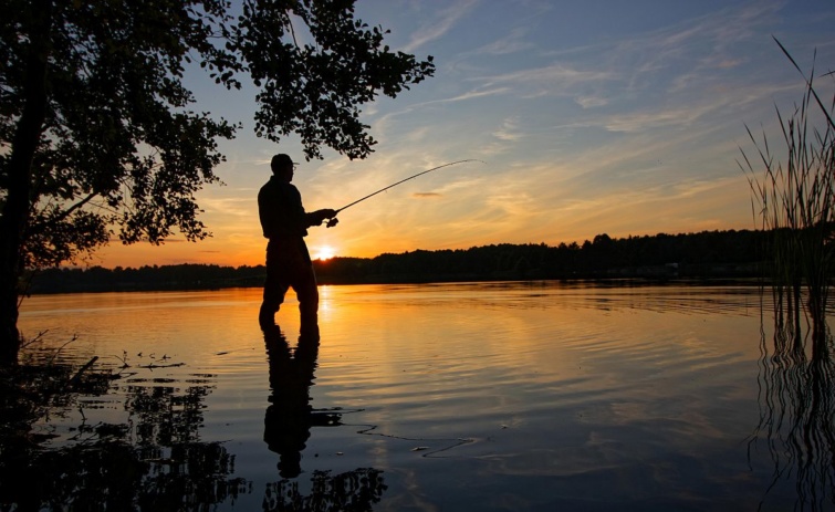 Egy férfi horgászik a naplementében.