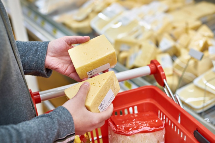 Egy vásároló a sajtokat nézi az egyik élelmiszerüzletben