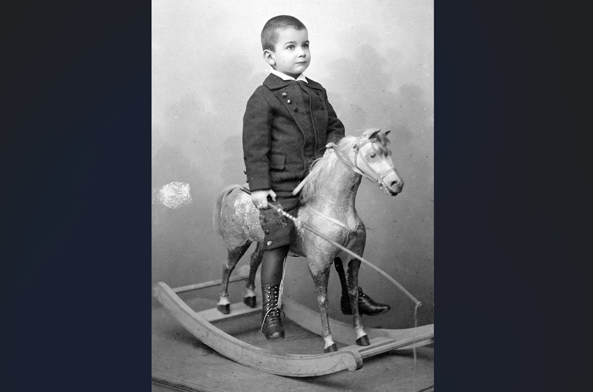 Egy kép 1915-ből, melyen egy kisfiú hintalovon ül