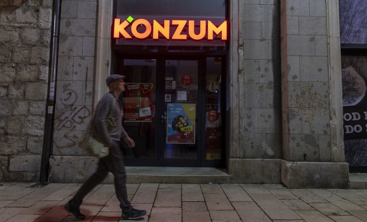 Egy férfi halad el egy bezárt Konzum élelmiszerbolt előtt Splitben.