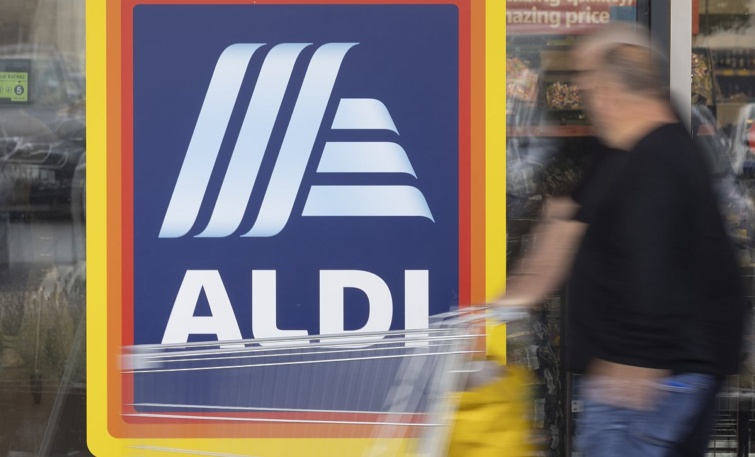 Egy vásárló bevásárlókocsit tol az Aldi egyik üzlete előtt.