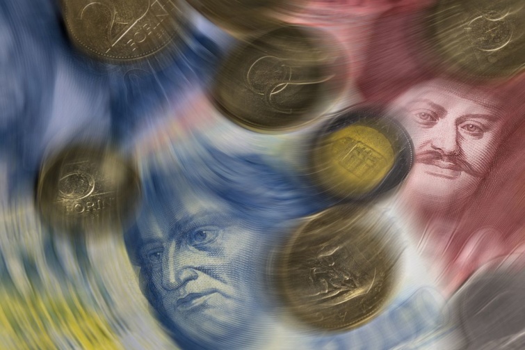 Forint bankjegyek és érmék elmosódott ábrázolása.