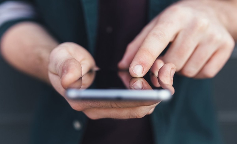mobiltelefonkez Startlap Vásárlás Egy ember mobiltelefonozik.