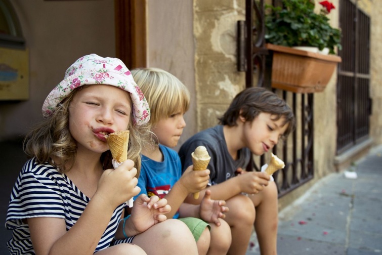Az utcán ülő gyerekek fagylaltoznak.