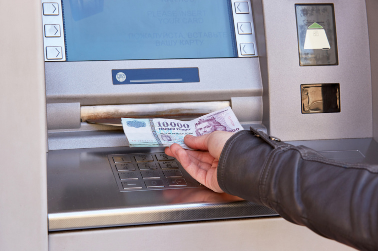 Valaki magyar forint készpénzt vesz fel egy ATM bankautomatából