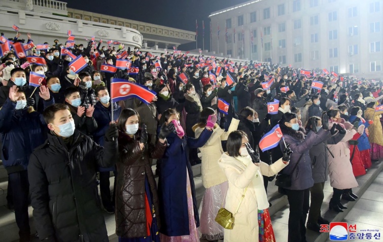 Észak-Korea hivatalos koreai központi hírügynöksége által közzétett képen emberek láthatóak, akik egy téren részt vesznek az újévi nemzeti zászlófelvonási ünnepségen