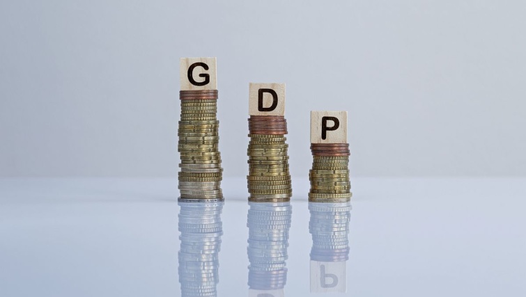 Csökkenő GDP illusztrációja pénzérmékkel.