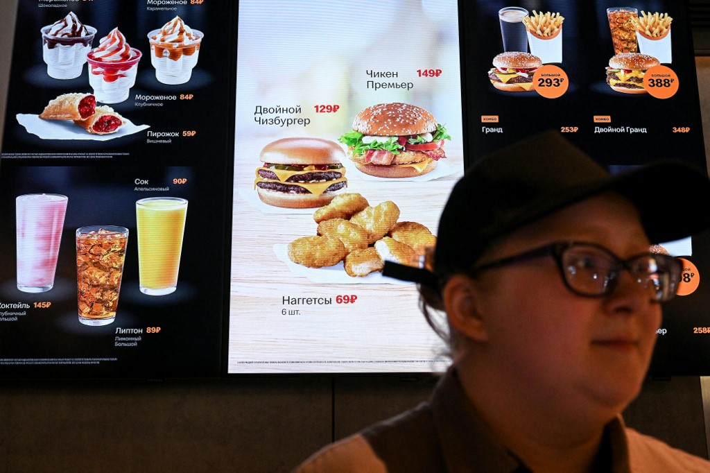Egy dolgozó a menü előtt áll az oroszországi McDonald's-ban, a Vkuszno-i Tocska-ban
