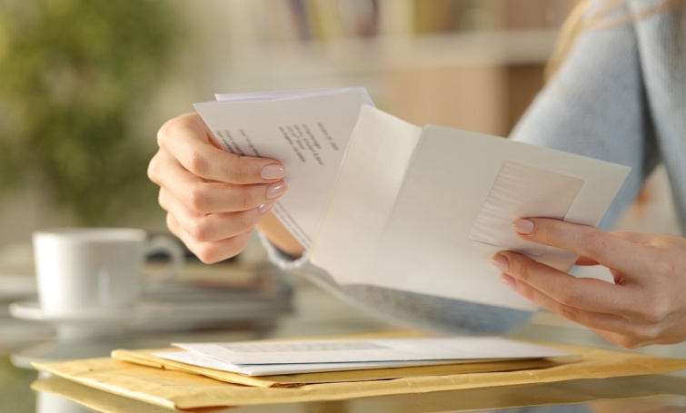 Egy női kéz egy levelet fog.