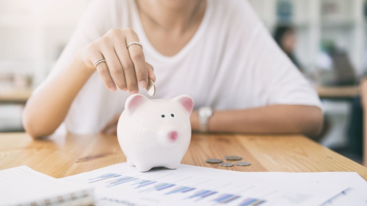 malacpersely Startlap Vásárlás Egy nő pénzt dob egy malacperselybe