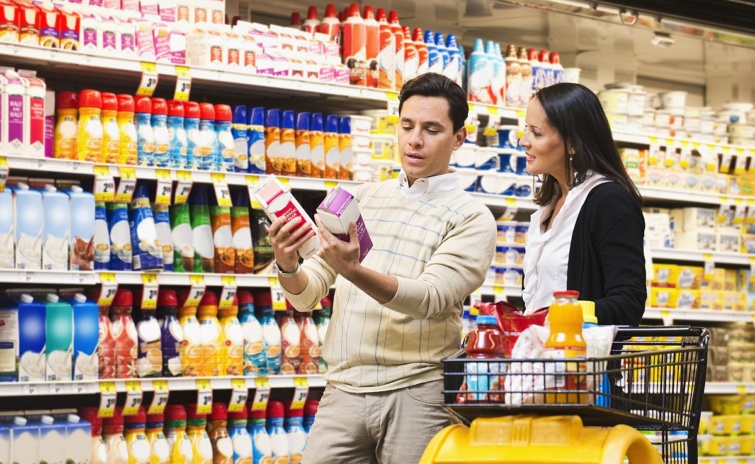Vásárlók két terméket vizsgálnak az élelmiszerboltban.