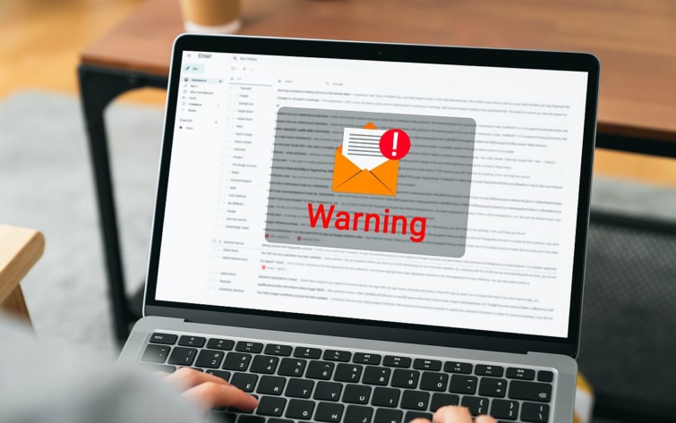 Laptop képernyőjén egy levél ikonja figyelmeztető felirattal.