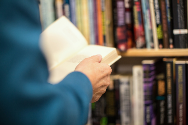Egy férfi egy könyvet lapozgat egy könyvesboltban