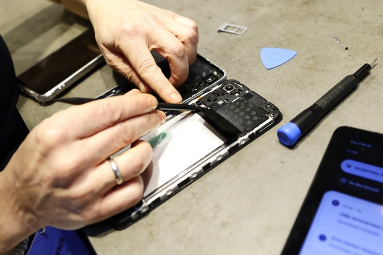 Egy elromlott mobiltelefont javítanak meg