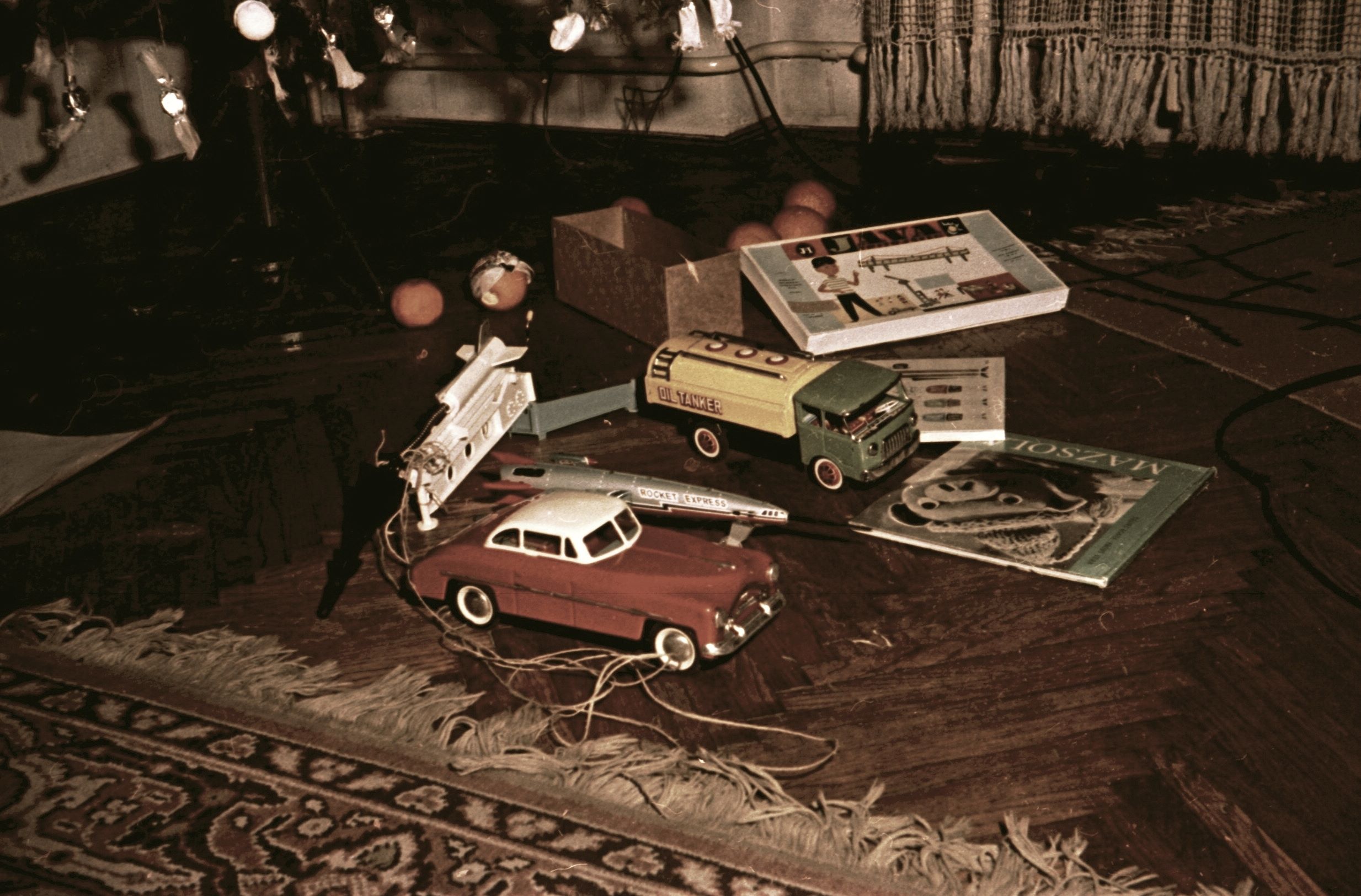 A karácsonyi ajándékok között elöl egy piros Lendület autó, Packard
