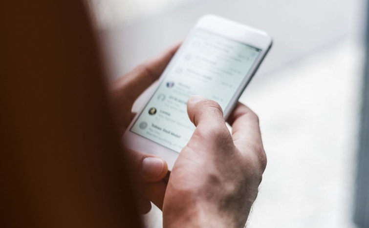 mobiltelefonkezuzenet Startlap Vásárlás Egy ember mobiltelefont tart a kezében.