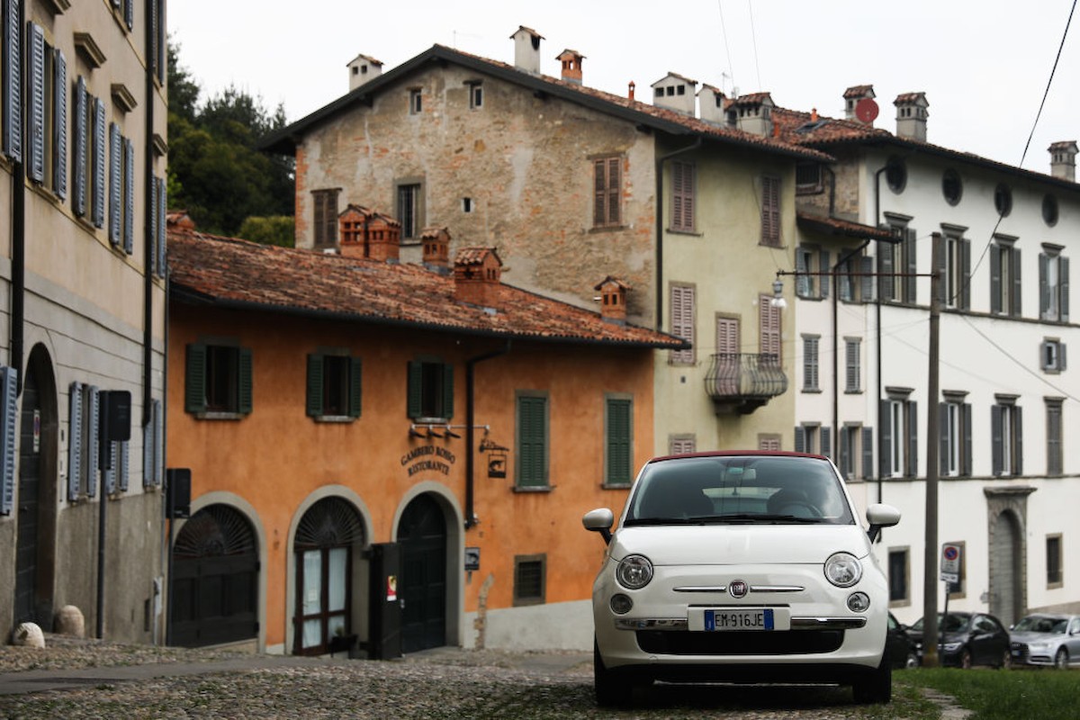 Egy Fiat kisautó parkol egy ház előtt