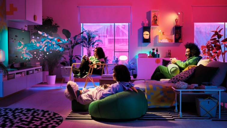 Modern nappaliban színes falak és ika bútorok között egy család videójátékozik