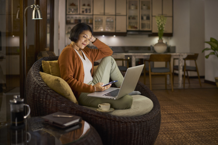Laptopozó és zenét hallgató nő fotelban