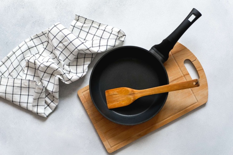 Serpenyő fehér asztalon, vágódeszkán