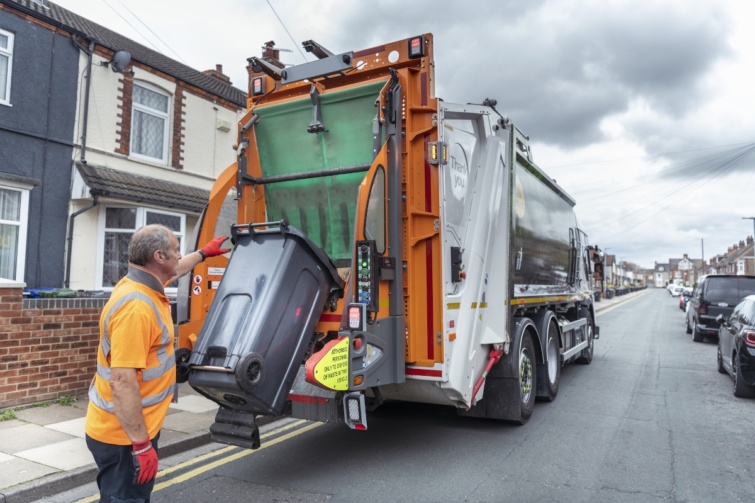Szemétszállító kocsi ürít egy kukát