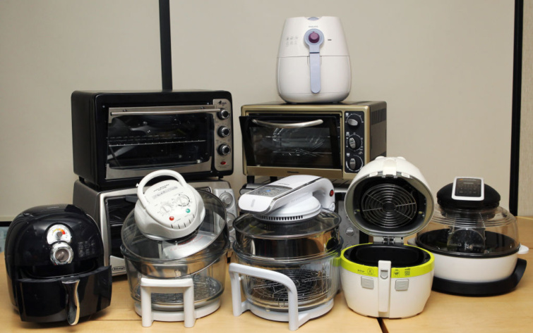 Többféle, sütésre alkalmas eszköz egymás mellett - köztük air fryer és halogén sütő