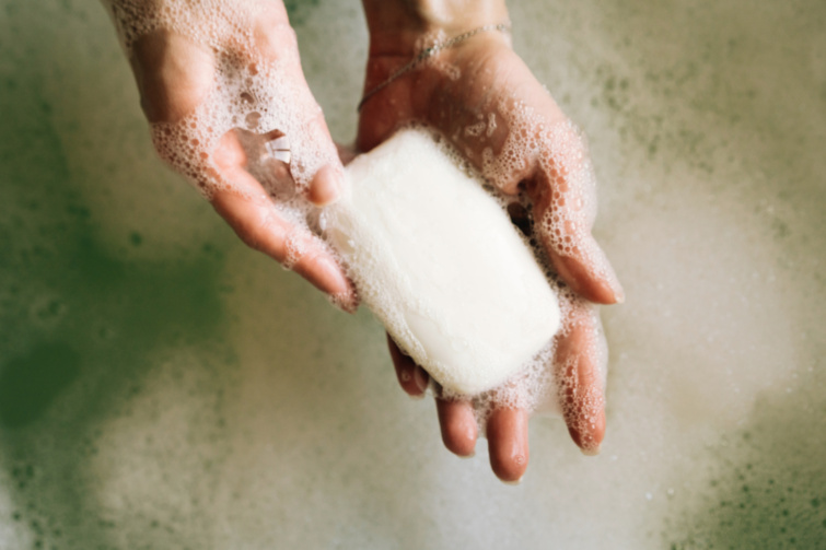 Szappannal kezet mosó női kéz