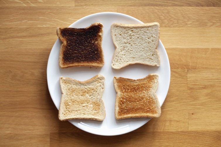 Négy darab különböző sütési fokozatú toast kenyér fehér tányéron
