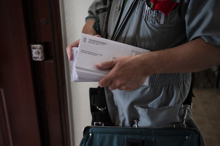 A Magyar Posta munkatársa kézbesíti a 30 ezer forintos élelmiszer-utalvány