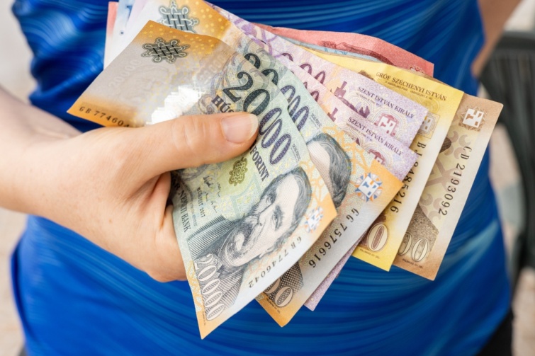 Egy nő forint bankókat tart a kezében