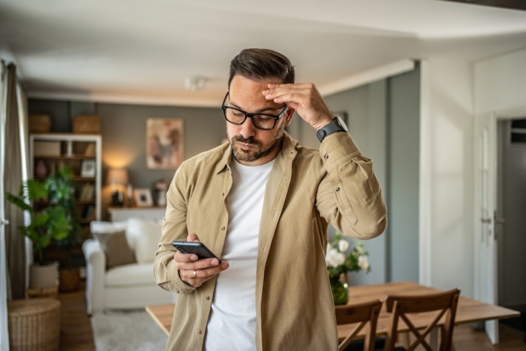 Telefont néző férfi