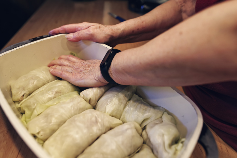 Idős nő töltött káposztát készít