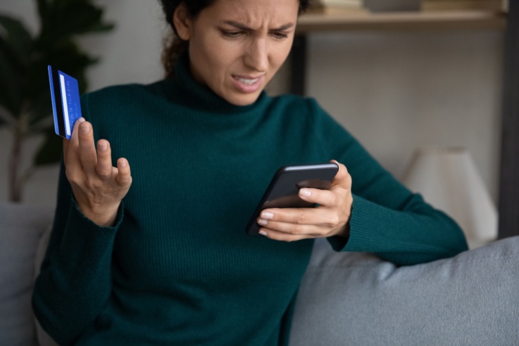 Fiatal nő mobiltelefonnal, bankkártyával