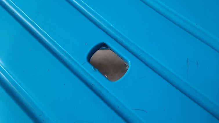 Egy kék műanyag szék közepén lyuk.