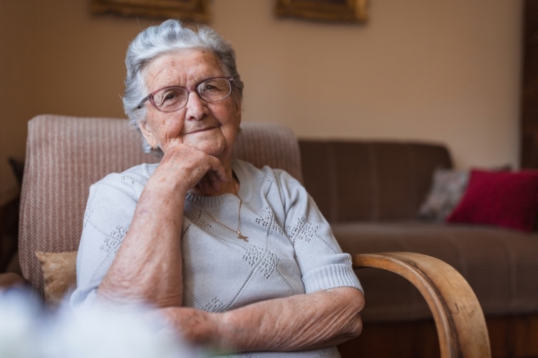 Nyugdíjas nő ül egy fotelban. 