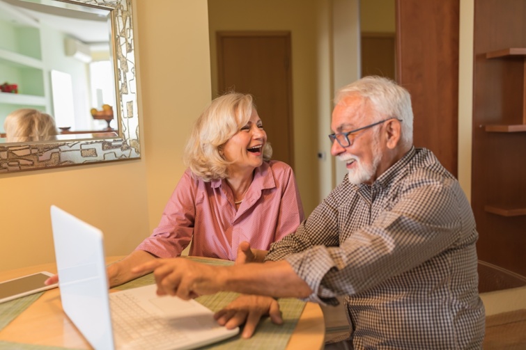 Vidám nyugdíjasok egy laptop előtt