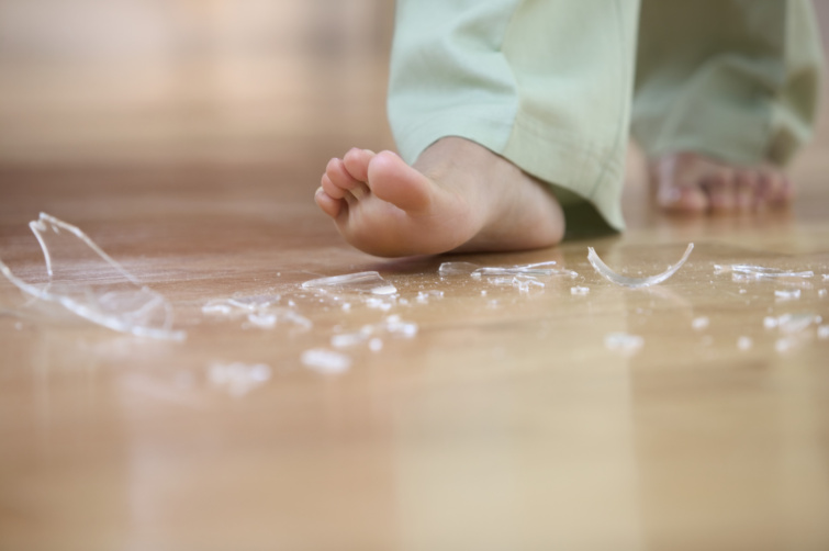 Üvegszilánkok a padlón gyerekkel.