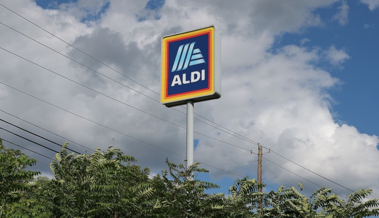 Aldi logó egy oszlop tetején a fák fölött.