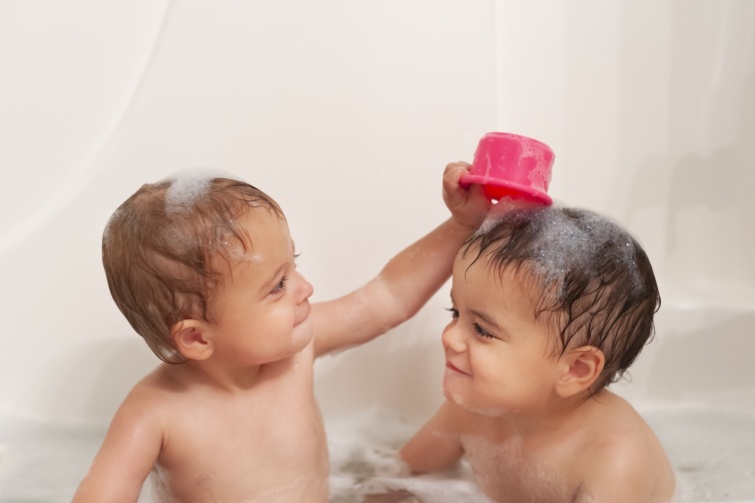 Két kisfiú pancsol a kádban