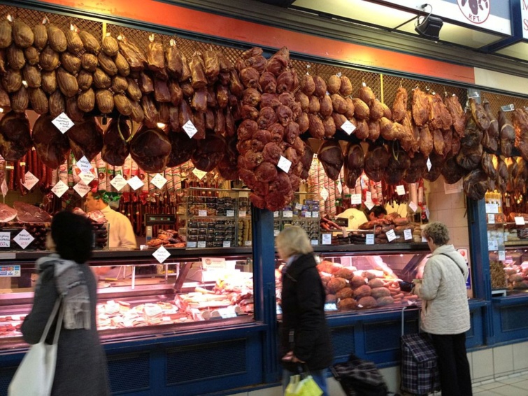 Vásárlók egy hentesbolt előtt egy budapesti piacon