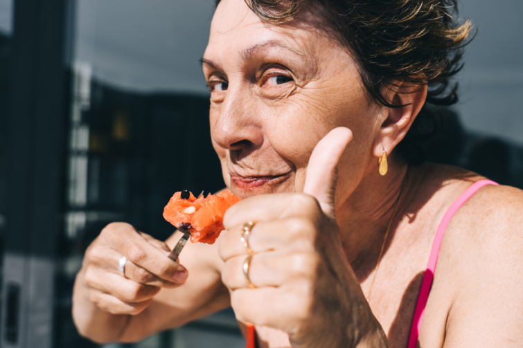 Idős nő boldogan étkezik