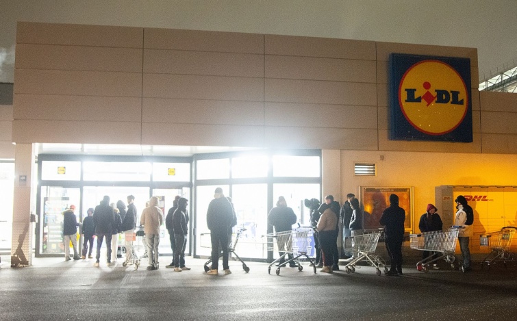 Nyitásra váró vásárlók sora egy Lidl-üzlet előtt.