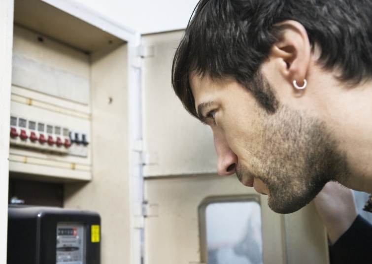 Egy férfi a villanyóra számlálóját nézi