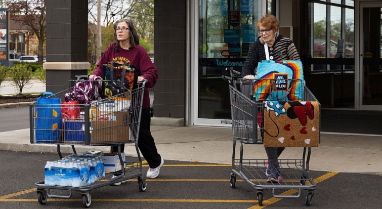 Két idős nő tömött bevásárlókocsival távozik az Aldi egyik üzletéből.
