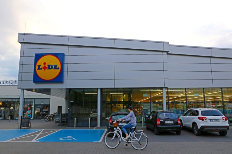 Lidl üzlet bejárata, előtte autók és egy biciklista